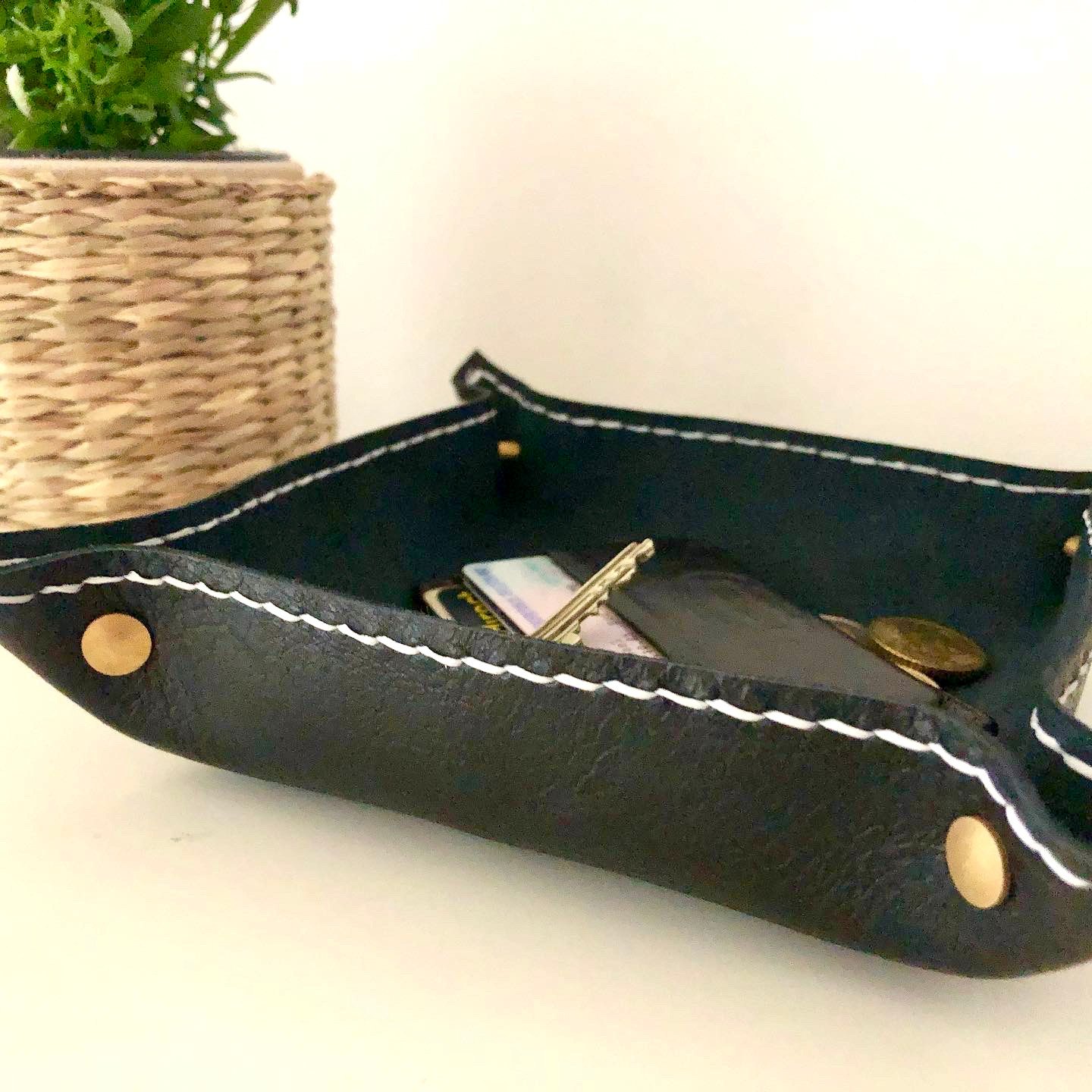 Black valet tray by 1985 Studio from the side: its grained black chrome-tanned leather, brass screw heads at the corners and white stitches