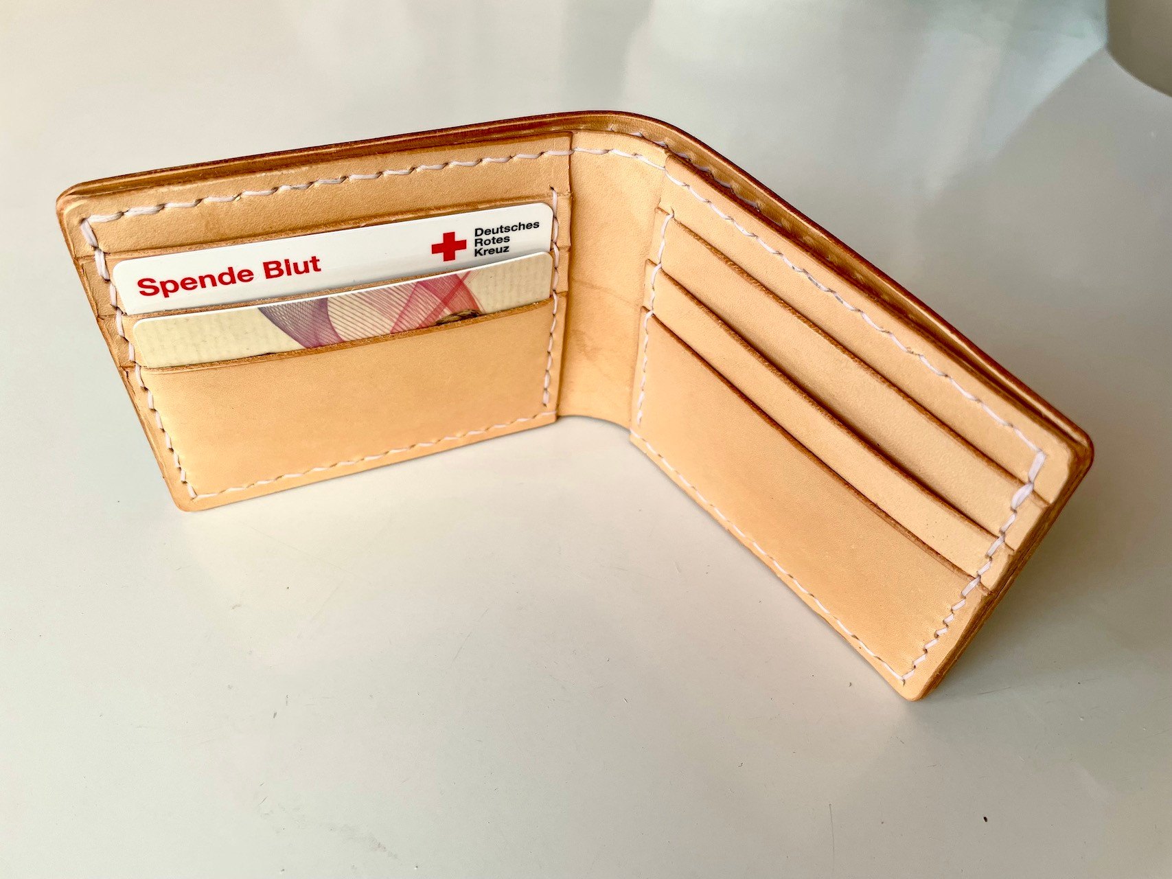 Wave Wallet by 1985 Studio opened, natural vegetable-tanned leather inside with card slots on both sides