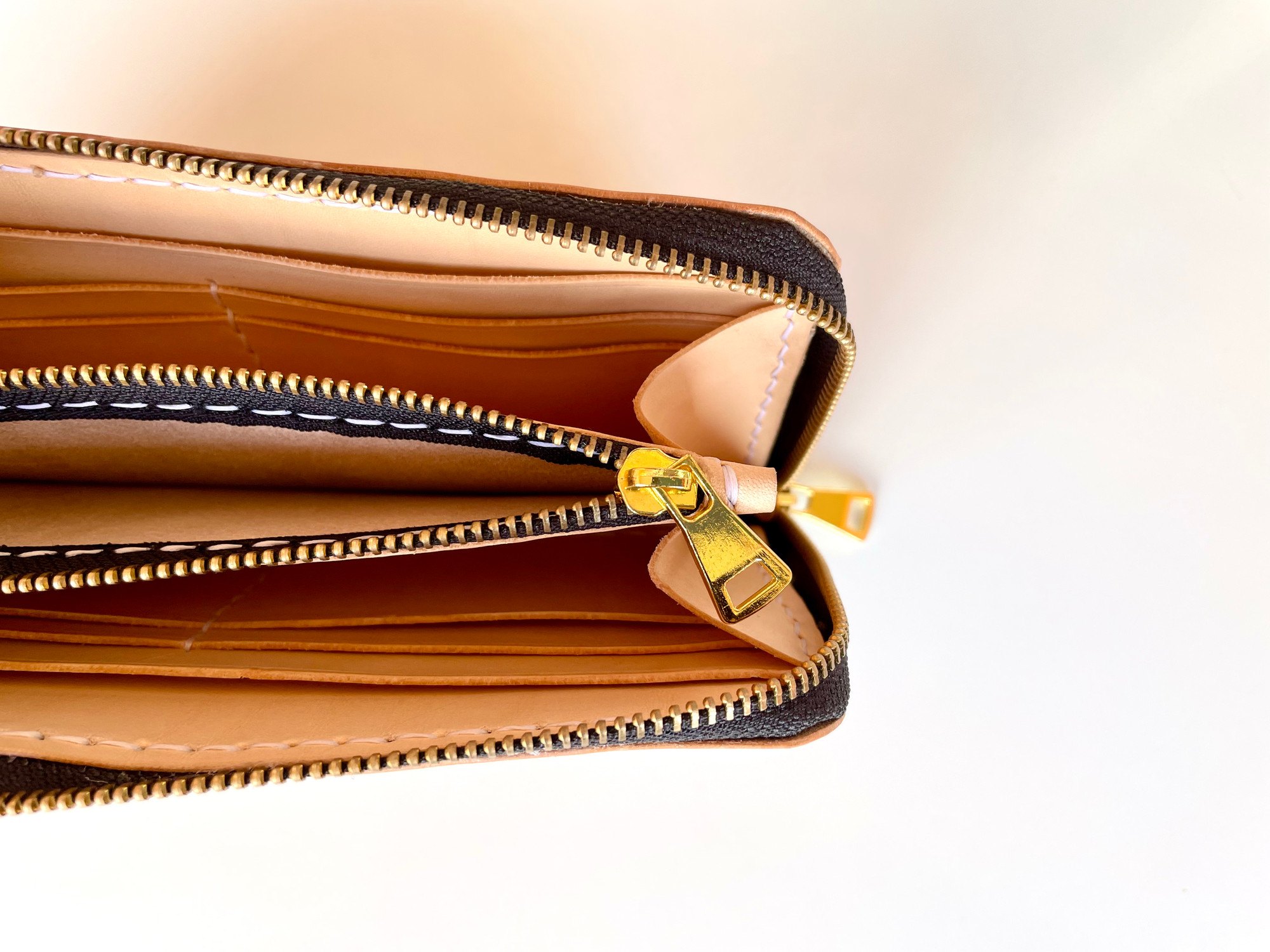 Geöffnete lange Geldbörse von 1985 Studio von oben, der Zipper des Münzfachs zwischen den Reihen von Kartenfächern aus pflanzlich gegerbtem Leder
