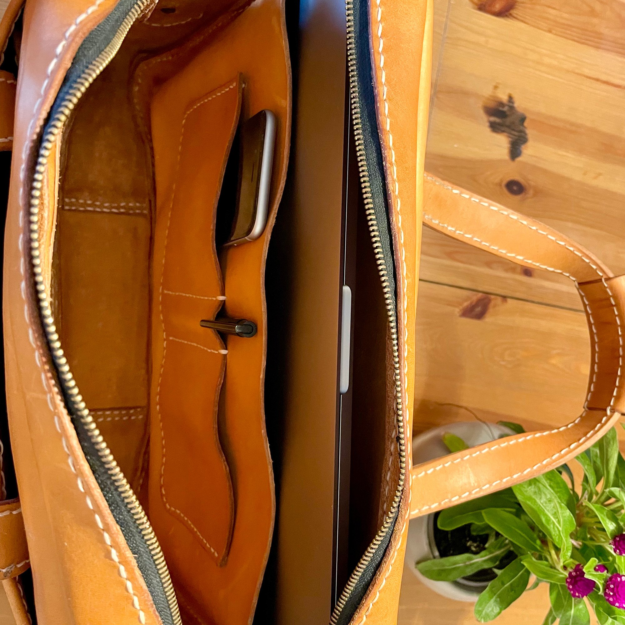 Inside the Munich Bag by 1985 Studio: a laptop in its sleeve and a phone in one of the inner pockets of vegetable-tanned leather
